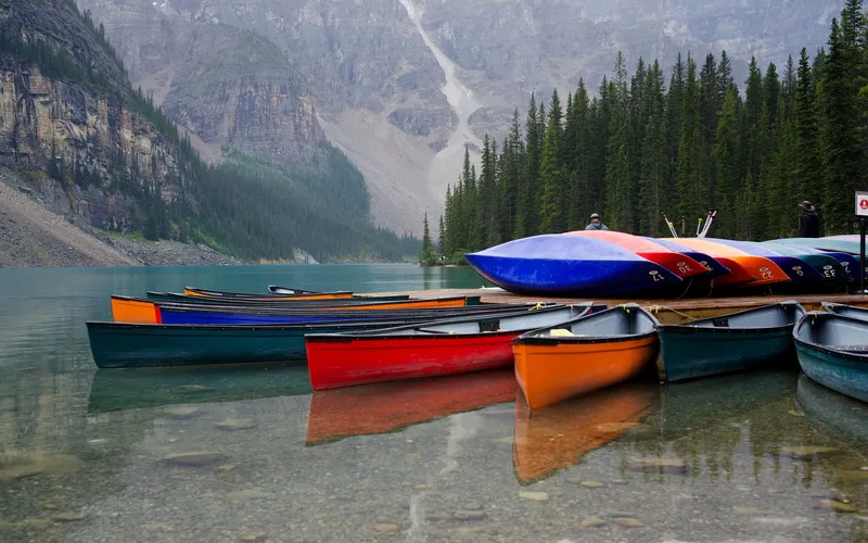 Bunte, nummerierte Leihkanus an einem Steg an einem Bergsee