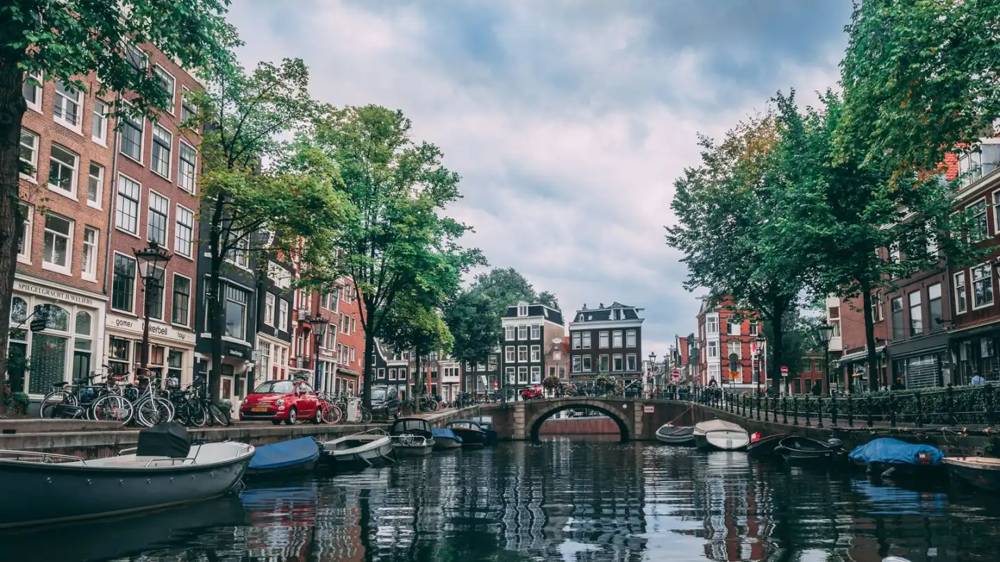 Sloepen aan de kade van een Amsterdamse gracht, met fietsen langs het water