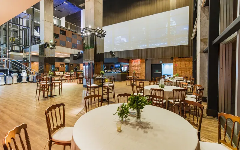 An event hall with round laid tables and wooden chairs